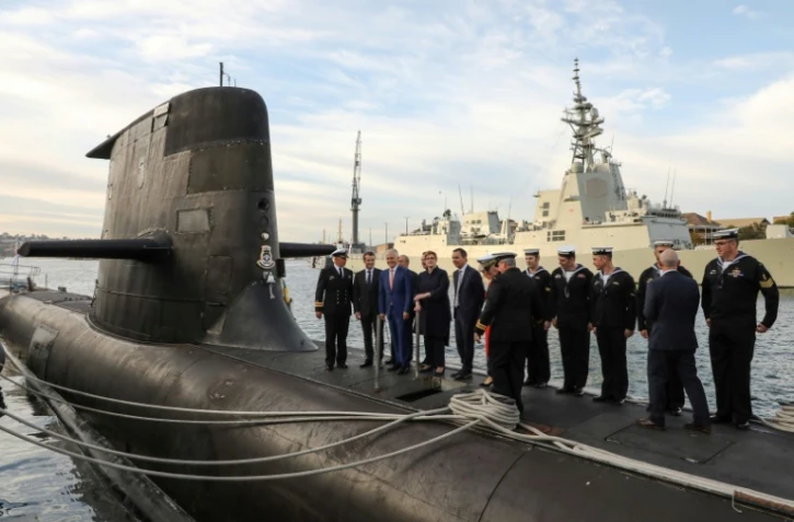 Le président français Emmanuel Macron (2e g) avec le Premier ministre australien de l'époque Malcolm Turnbull (3e d) sur le pont du HMAS Waller, le 2 mai 2018 à Sydney
