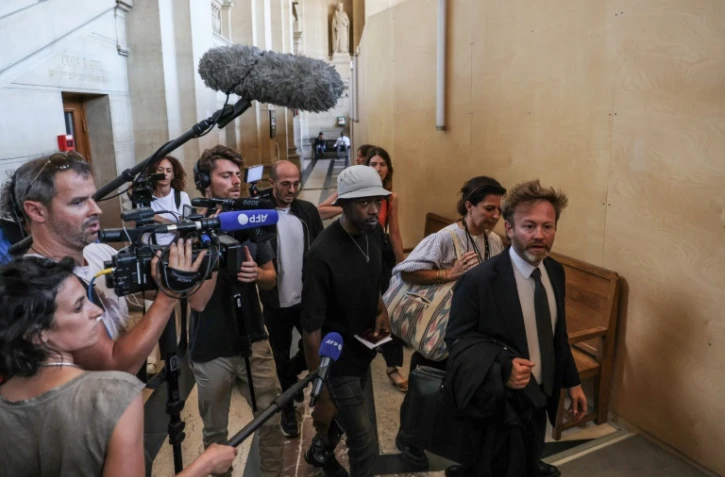 Le rappeur français Mohamed Sylla (C), alias MHD, arrive au palais de justice de Paris le 4 septembre 2023 avec ses avocats Antoine Vey (D) et Elise Arfi (2e D) pour le début de son procès aux assises
