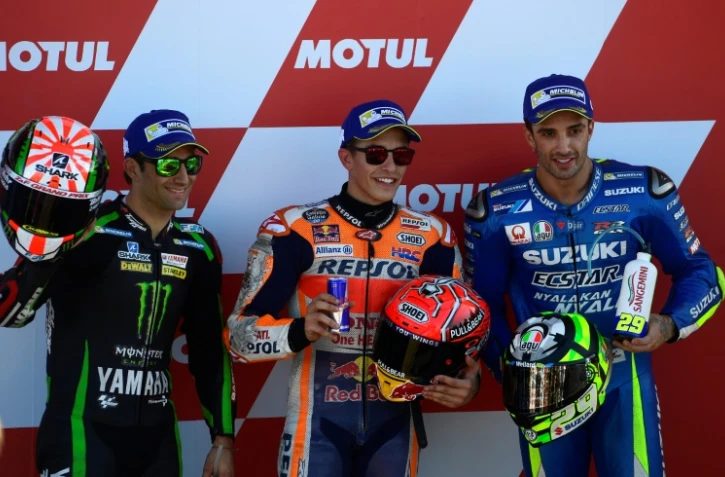 L'Espagnol Marc Marquez (c) pose sur le podium après avoir remporté la pole pour le GP de Valence, catégorie MotoGP, le 11 novembre à Cheste près de Valence