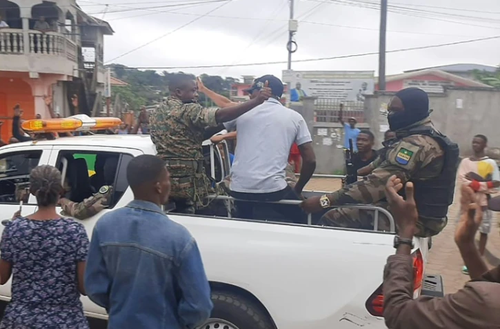 Des habitants applaudissent des membres des forces de sécurité dans le quartier Plein Ciel, à Libreville, le 30 août 2023 au Gabon