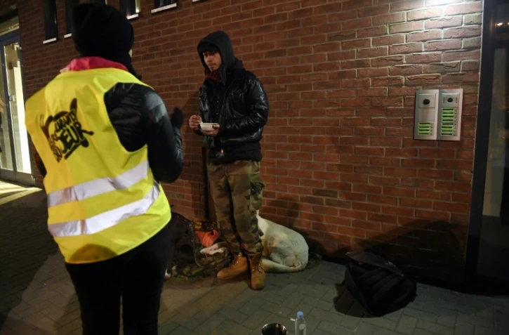 Une volontaire des Restos du Coeur apporte un repas à un sans-abri à Strasbourg, où la température est descendue à -7 degrés en soirée le 26 février 2018