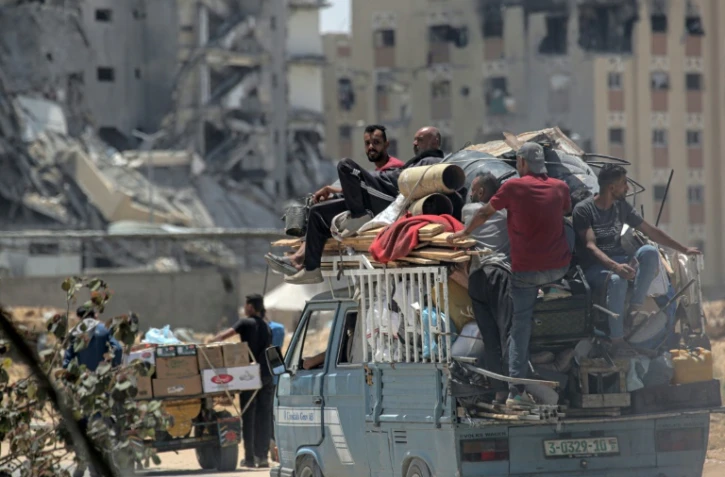 Des Palestiniens qui ont fui Rafah, dans le sud de la bande de Gaza, transportent leurs affaires à l'arrière d'un camion alors qu'ils arrivent pour s'abriter à Khan Yunis, le 12 mai 2024