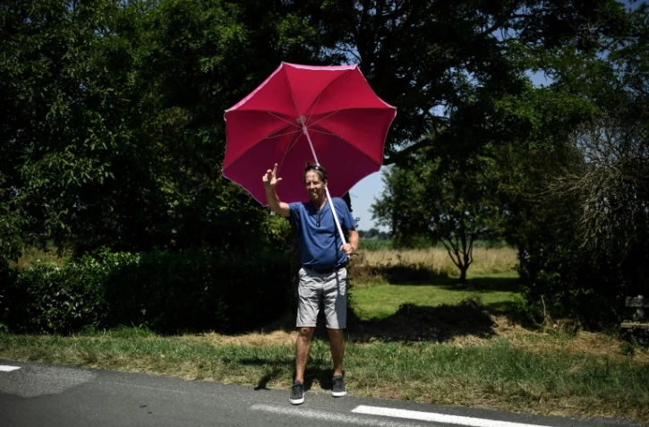 Un spectateur sous un parasol lors de la 18e étape du Tour de France, entre Trie-sur-Baïse et Pau, le 26 juillet 2018