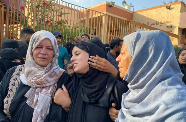 Des femmes palestiniennes de la bande de Gaza pleurent des proches lors de leurs funérailles après qu'ils ont été tués par une frappe israélienne sur un camp de personnes déplacées, à l'hôpital Nasser de Khan Younès le 2 juillet 2025