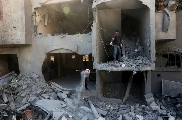 Des Palestiniens déblaient les décombres d'un bâtiment touché par un bombardement à Nousseirat, dans le centre de la bande de Gaza, le 12 août 2024