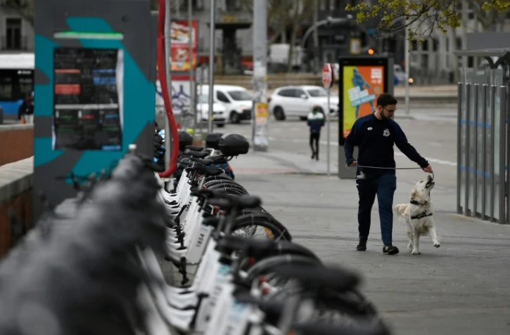 Un homme promène son chien à Madrid, le 16 mars 2020.