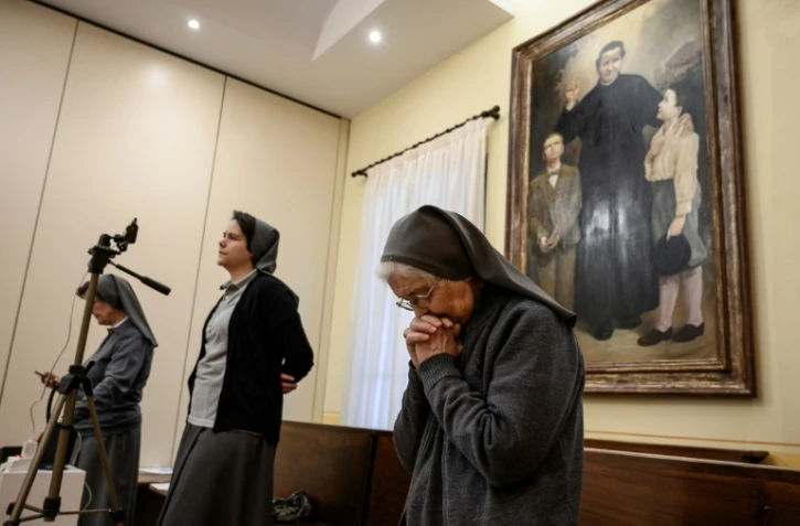 Des religieuses prient lors d'une messe retransmise en streaming à la chapelle Saint Jean Bosco à Saluces, dans le Piemont, nord de l'Italie, le 22 mars 2020
