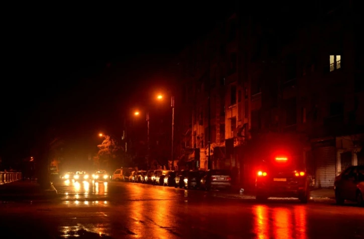 Des voitures roulent dans une rue éclairée d'Alep, le 5 mars 2016