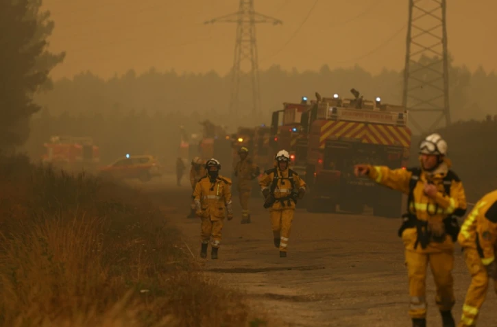 Des pompiers s’efforcent d’éteindre un incendie à Marcheprime, à l’ouest de Bordeaux, le 26 juillet 2026, alors qu’un feu de forêt ravage le massif situé au nord du bassin d’Arcachon (Gironde) depuis le 22 juillet