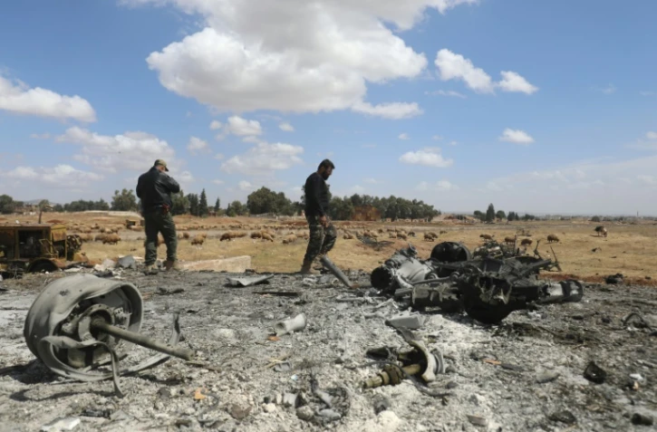 Des hommes sur le site d'une frappe israélienne dans le gouvernorat de Hama, dans le sud de la Syrie, le 3 avril 2025