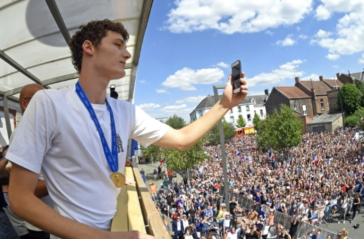 Le défenseur de l'équipe de France Benjamin Pavard prend en photo la foule venue le féliciter à Jeumont dans le Nord de la France, ville où il a grandi, le 18 juillet 2018