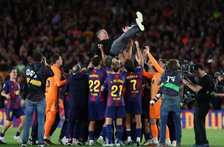 L'entraineur du Barça Hansi Flick porté en triomphe par ses joueurs après la victoire dans le Clasico face au Real Madrid, synonyme de titre de champion d'Espagne, le 10 mai 2026 au Camp Nou