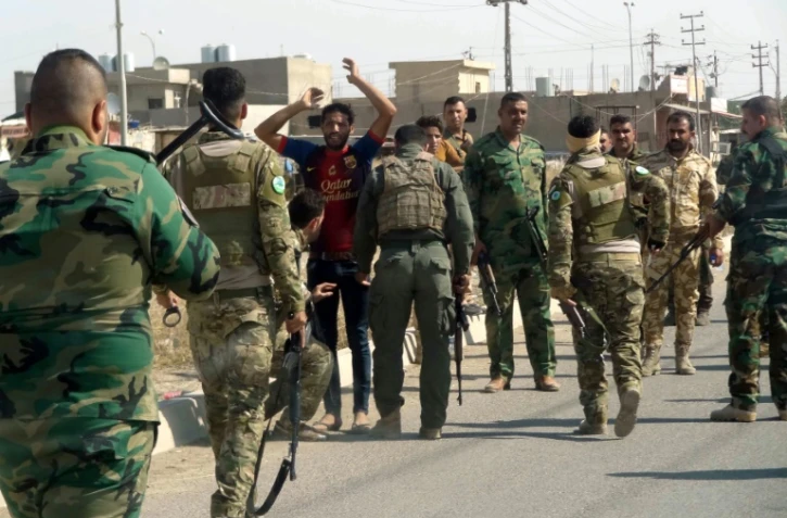 Des forces de sécurité kurdes arrêtent un homme suspecté d'être membre de l'EI lors d'une patrouille dans les quartiers est de Kirkouk, le 22 octobre 2016