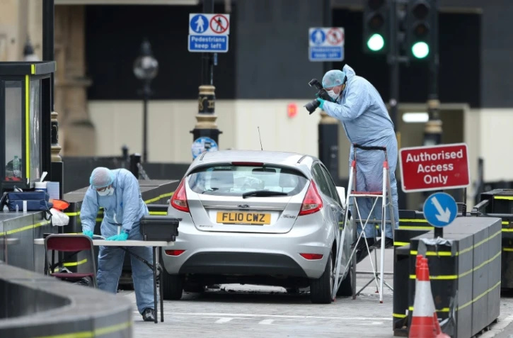Des policiers à l'oeuvre sur le lieu de l'attentat à la voiture-bélier près du parlement à Londres, le 14 août 2018
