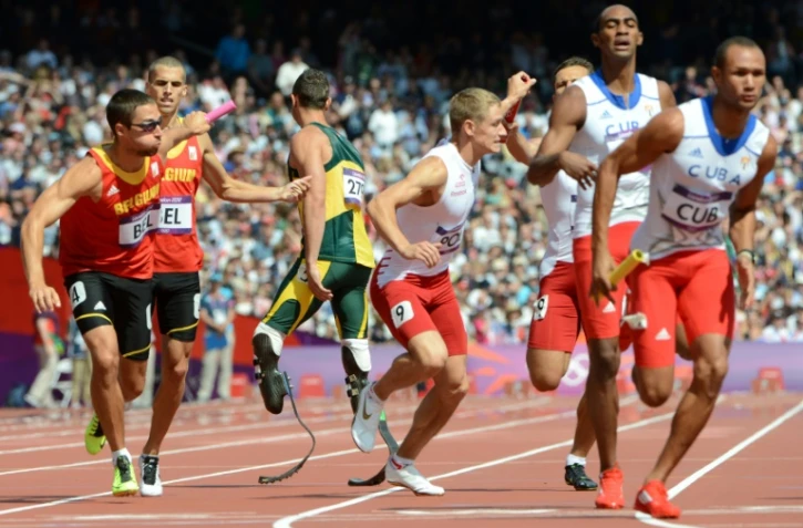 Oscar Pistorius, entouré des athlètes belges, polonais et cubains, le 9 août 2012 pendant les qualifications pour le 4x400 m des JO-2012 de Londres