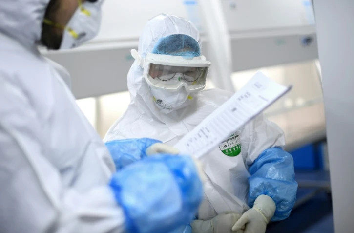 Un technicien examine des échantillons testés à Wuhan 