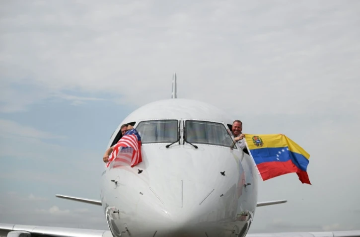Les pilotes du vol 3599 d'American Airlines, reliant l'aéroport international de Miami à Caracas, au Venezuela, agitent des drapeaux vénézuéliens et américains avant de décoller pour un vol direct vers le Venezuela, le premier entre les États-Unis et le Venezuela en sept ans, le 30 avril 2026 à l'aéroport international de Miami, en Floride