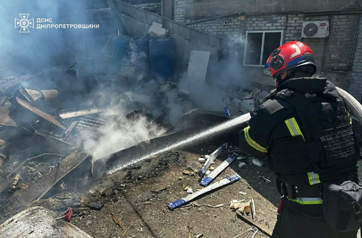 Photo prise et diffusée le 24 juin 2025 par le Service d'urgence de l'État ukrainien d'un pompier éteignant un incendie après une frappe de missile russe à Dnipro, dans l'est de l'Ukraine