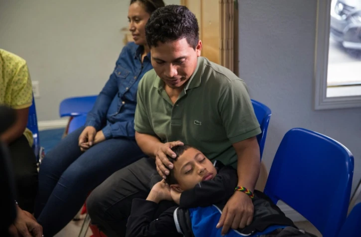 Un immigrant du Salvador et son fils de 10 ans dont le père dit avoir été séparé durant sa détention sont réunis le 17 juin 2018 dans un centre d'aide catholique de McAllen au Texas