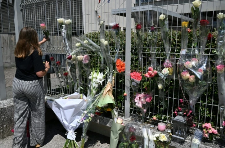 Une élève dépose une fleur sur les grilles du collège Françoise-Dolto à Nogent, au lendemain du meurtre d'une surveillante, le 11 juin 2025 en Haute-Marne
