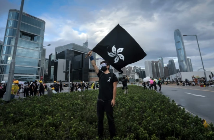 Un manifestant agite un drapeau hongkongais noir au lieu du rouge officiel, le 1er juillet 2019