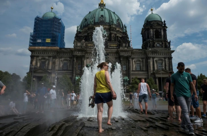 Des visiteurs se rafraïchissent dans la fontaine de la cathédrale de Berlin, le 4 août 2018