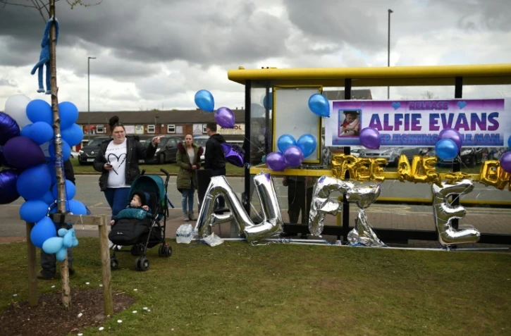 Des affiches et des ballons accrochés en soutien au petit Alfie à un arrêt de bus devant l'hôpital pour enfants Alder Hey de Liverpool (nord-ouest de l'Angleterre) le 26 avril 2018