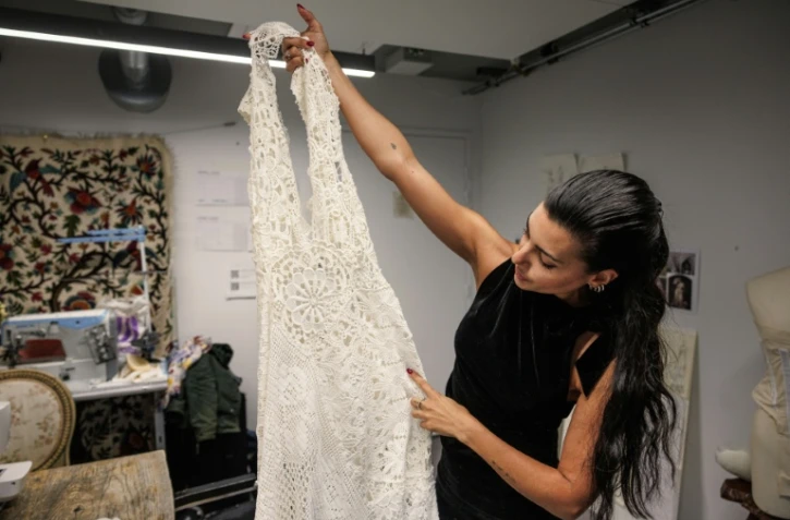 La créatrice, directrice artistique et styliste espagnole Maria Bernad, fondatrice de l'atelier Les Fleurs Studio, travaille sur une pièce réalisée à partir de dentelles anciennes, le 5 mai 2026 à Paris