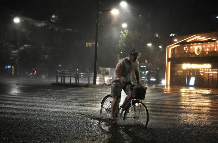 Un homme se déplace à vélo dans Tokyo, la capitale japonaise frappée par le typhon Faxai le 9 septembre 2019