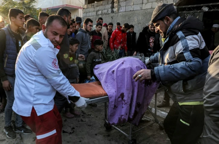 Des secouristes évacuent les corps des victimes d'une frappe israélienne qui a détruit une voiture de police, le 6 février 2024 à Rafah, dans le sud de la bande de Gaza