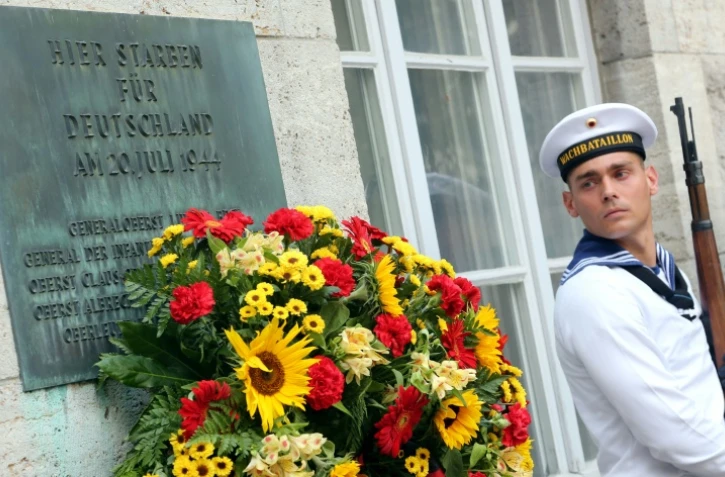 Un soldat allemand près d'une plaque à la mémoire des officiers fusillés pour leur implication dans l'attentat contre Hitler en 1944, au mémorial de la résistance allemande à Berlin le 20 juillet 2014