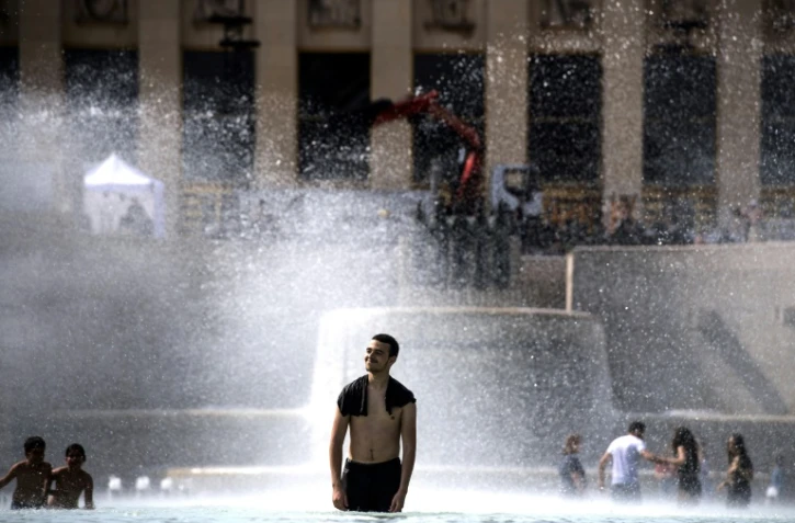 Des jeunes se rafraîchissent dans une fontaine de l'esplanade du Trocadéro à Paris, le 24 juin 2019
