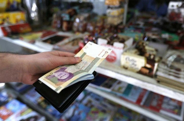 Un homme tient des rials iraniens dans une rue de Téhéran, le 31 juillet 2018