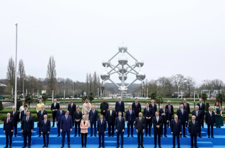 Les dirigeants et représentants des pays participants au sommet sur l'énergie nucléaire organisé par l'Agence internationale de l'énergie nucléaire (AIEA) à Bruxelles le 21 mars 2024 posent devant le monument de l'Atomium