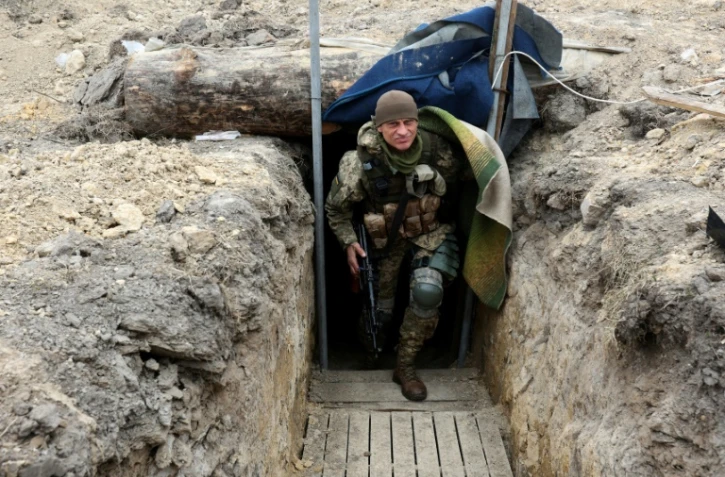 Un soldat ukrainien dans une tranchée d'une ligne de front dans le nord de Kiev, le 28 mars 2022
