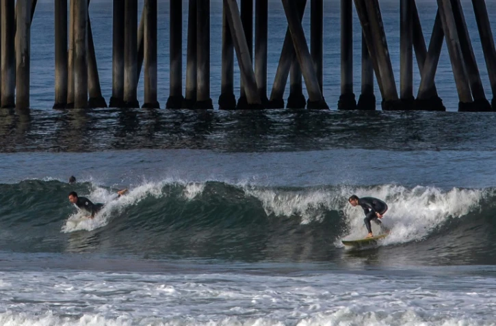 Des surfeurs près de la jetée d'Huntington Beach, le 2 mars 2020 en Californie