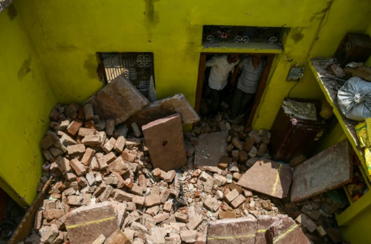 Des voisins regardent le plafond qui s'est effondré sur Sunil Kumar, 24 ans, lors d'une tempête à Kheragarh dans les environs d'Agra, en Inde le 4 mai 2018.