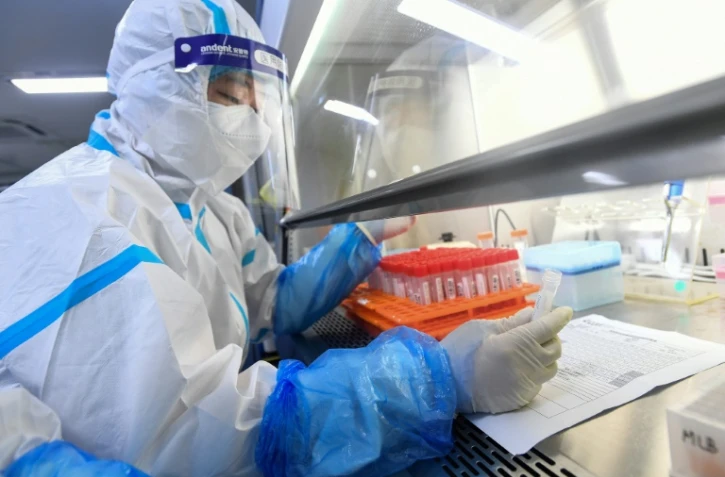 Un technicien travaille sur des prélèvements de tests Covid dans un laboratoire de Wuhan, le 4 août 2021 en Chine