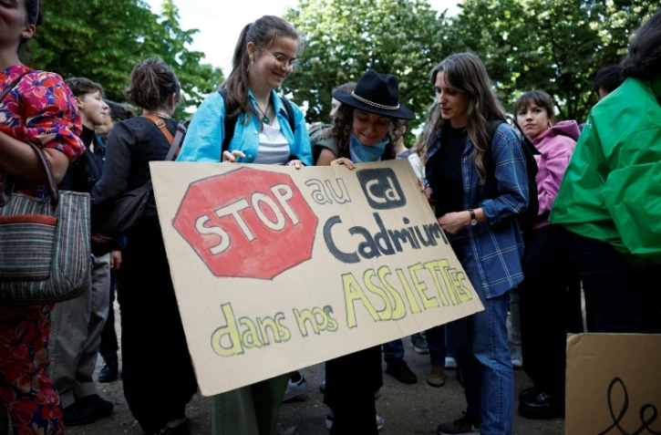 Des manifestants brandissent une pancarte sur laquelle on peut lire "Stop au cadmium dans nos assiettes" lors d'une manifestation aux côtés de députés, sur l'esplanade des Invalides à Paris, le 2 juin 2026