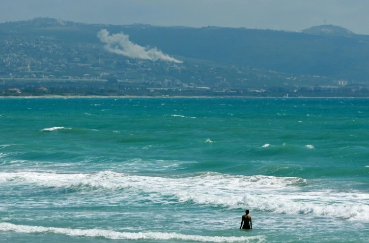 Une personne prend un bain de mer face au village d'El Mansouri, dans le sud du Liban, pendant un bombardement israélien le 22 mai 2026