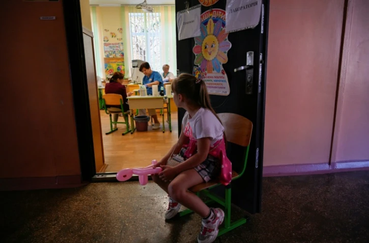Une enfant attend d'être examinée par un médecin à Myrne, le 14 septembre 2023 en Ukraine