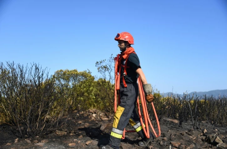 Un pompier porte un tuyau près du Luc (Var) le 19 août 2021