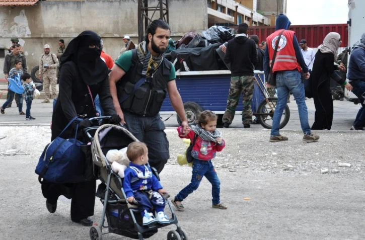 Des rebelles syriens et leurs familles en passe d'être évacués du quartier de Waer, à Homs, le 20 mai 2017