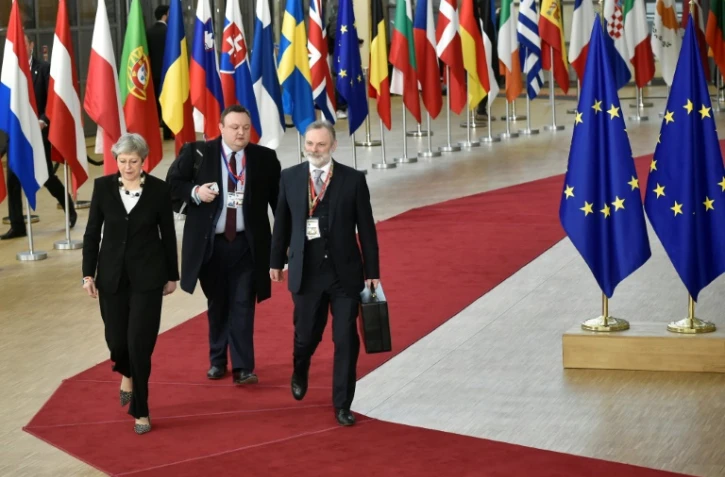 La Première ministre britannique Theresa May (G) arrive au siège de la Commission européenne à Bruxelles (Belgique), le 23 mars 2018