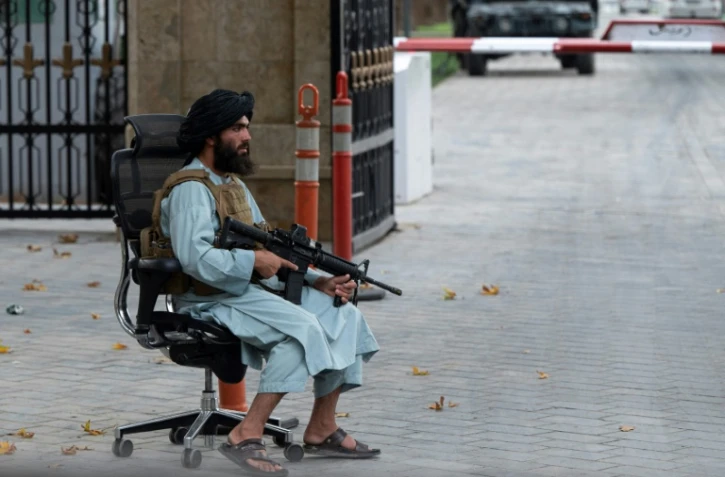 Un combattant taliban en faction après une réunion à laquelle participait le Premier ministre Mohammad Hassan Akhund à Kaboul le 13 août 2022