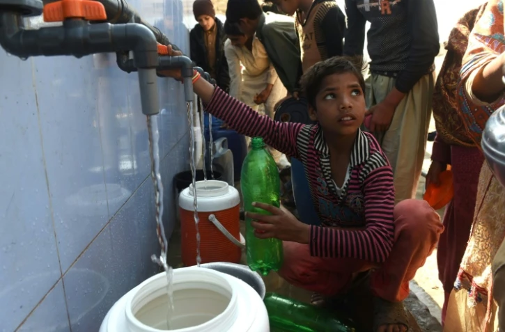 Un enfant remplit son bidon d'eau filtrée à Kot Assadullah au Pakistan, le 25 février 2018