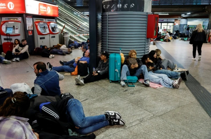 Des voyageurs se préparant à passer la nuit à la gare d'Atocha, à Madrid, à cause de la panne d'électricté géante, le 28 avril 2025