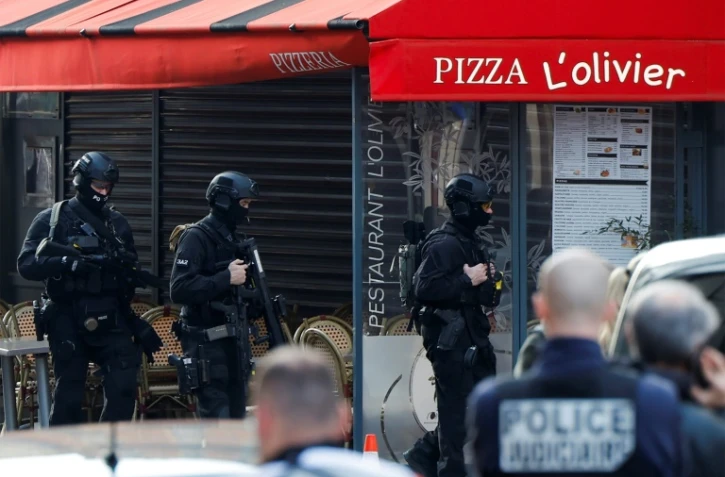 Des policiers devant la pizzeria où un homme s'est retranché à Issy-les-Moulineaux, près de Paris, le 16 novembre 2024