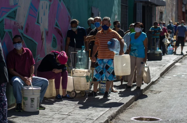Des habitants de Caracas attendent pour remplir leurs bidons d'eau le 27 mars 2020