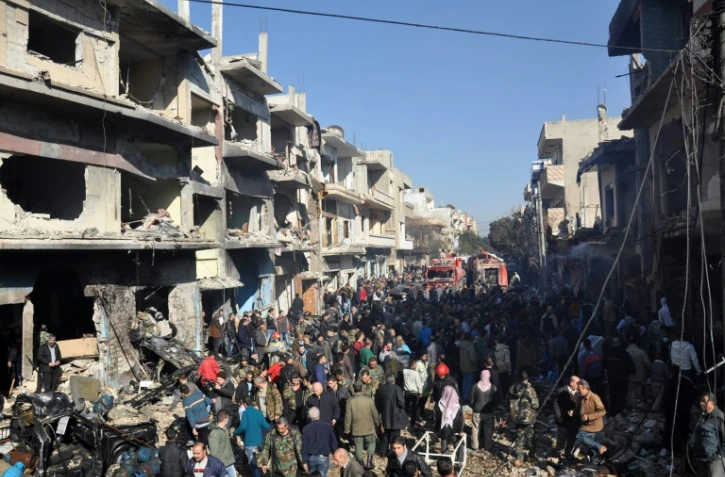 Des syriens dans une rue de Al-Zahra, un quartier prorégime de Homs, où a eu lieu un attentat à la voiture piégée qui a fait 15 morts, le 12 décembre 2015